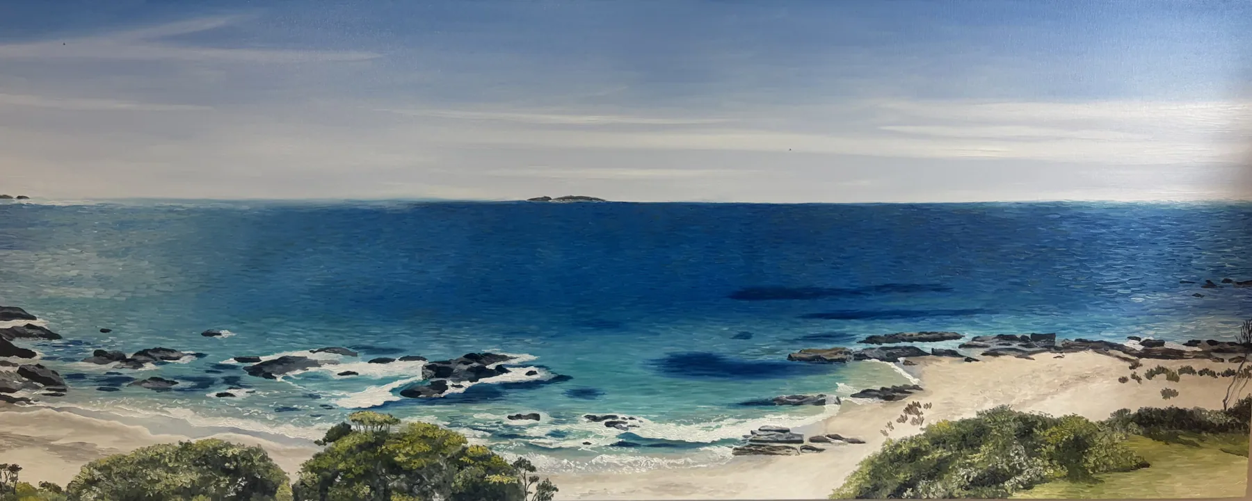 Wide oil painting looking over coastal scrub to a rocky bay and deep blue ocean